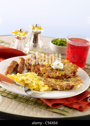 Crêpes aux pommes de terre avec des oeufs, des saucisses et du jus de canneberge Banque D'Images