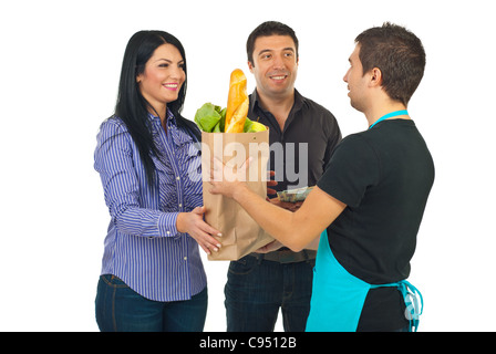 Commis d'épicerie man giving sac de papier avec de la nourriture pour le couple isolé sur fond blanc Banque D'Images