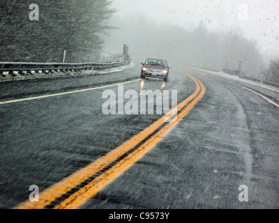 Une voiture roulant sur la Route 2 pendant une tempête de neige Banque D'Images