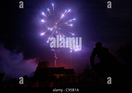 Un homme en silhouette regardant les feux d'artifice au-dessus de l'église à East Hoathly, East Sussex, UK Carnival Night 2011. Banque D'Images