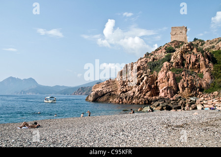 Une plage rocheuse au-dessous d'un fort de Génoise dans la ville de Porto, sur le golfe de Porto, sur la côte ouest de l'île de Corse, en France. Banque D'Images