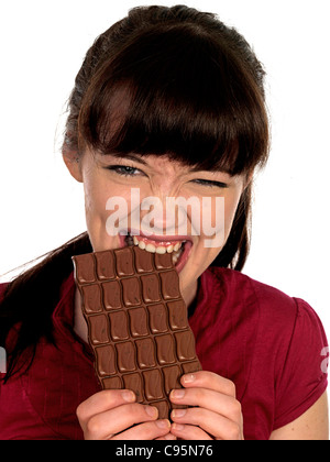 Jeune femme modèle publié de manger du chocolat. Banque D'Images