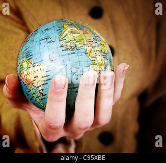 Globe in a girl's hands. Macro image Banque D'Images