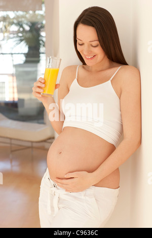 Femme enceinte de boire du jus d'orange. Banque D'Images