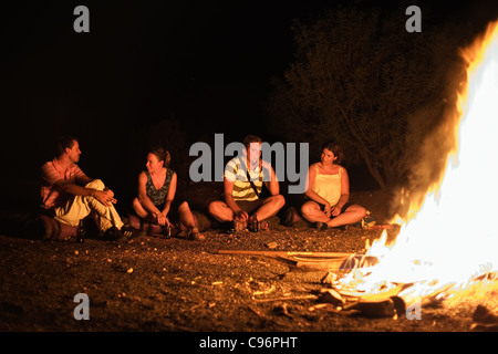 Les touristes s'asseoir autour du feu de camp dans l'outback australien. Curtin Springs, Territoire du Nord, Australie Banque D'Images