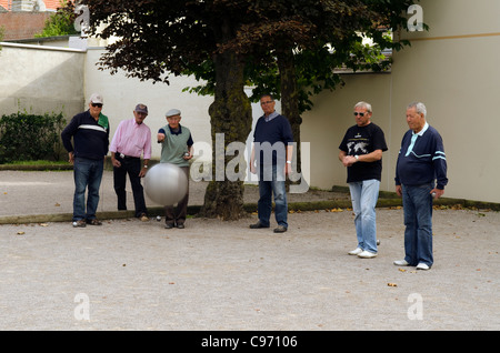 Un groupe d'hommes français jouer aux boules dans un petit espace ouvert dans le Touquet France Banque D'Images