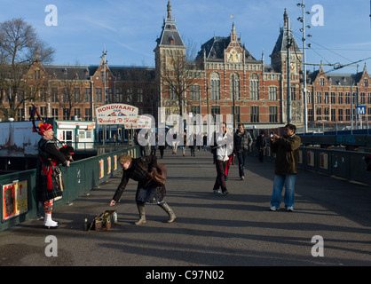 Piper écossais jouer de la cornemuse, de la rue en face de la Gare Centrale d'Amsterdam Banque D'Images