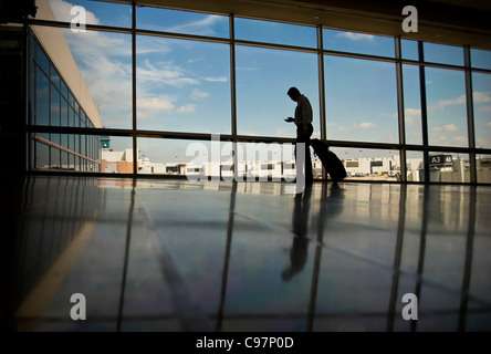 L'homme d'affaires en déplacement de lire vos e-mails sur Mobile Cell Phone In Airport, Philadelphie USA Banque D'Images