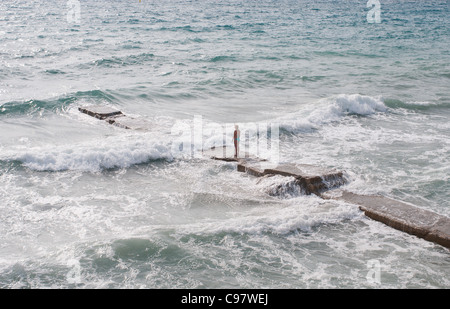 La seule figure d'une femme dans un bikini fait face à la mer sur la plage de Camp de Mar, à proximité de Port d'Andratx de Majorque Banque D'Images