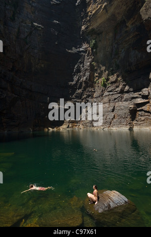 Les touristes nager dans les Jim Jim Falls piscine, entourée par des murs de l'escarpement. Le Kakadu National Park, Territoire du Nord, Australie Banque D'Images