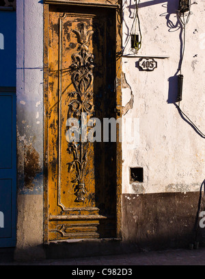 La fin de l'après-midi vue de ornately porte en bois sculpté sur les rues de La Havane, Cuba.La porte est très connu par des fissures. Banque D'Images