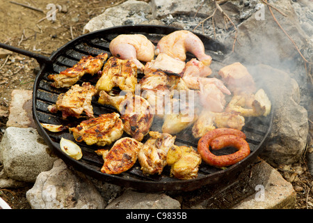 Griller à feu ouvert avec de la viande de porc, des saucisses et du poulet Banque D'Images