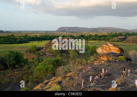 Les touristes regardant le coucher du soleil sur le site d'Ubirr autochtones sacrés. Le Kakadu National Park, Territoire du Nord, Australie Banque D'Images