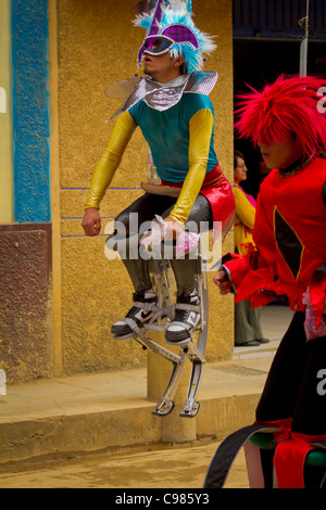 Acrobates sur échasses rebondissantes de divertir la foule dans une rue à Celendin parade, au Pérou. Banque D'Images