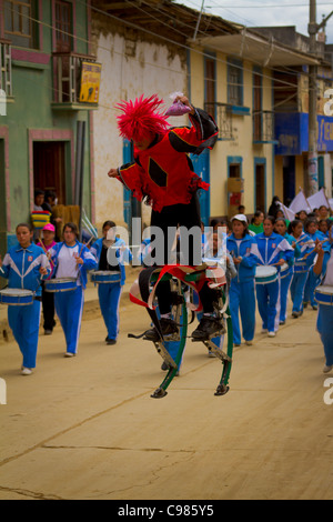 Acrobates sur échasses rebondissantes de divertir la foule dans une rue à Celendin parade, au Pérou. Banque D'Images