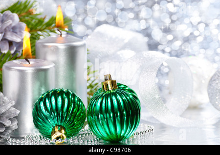 Boules de Noël avec des bougies d'argent sur fond lumineux Banque D'Images