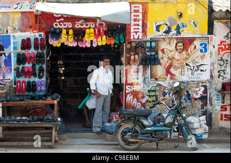 Propriétaire de magasin de chaussures indiennes debout dans l'entrée de son magasin. L'Andhra Pradesh, Inde Banque D'Images