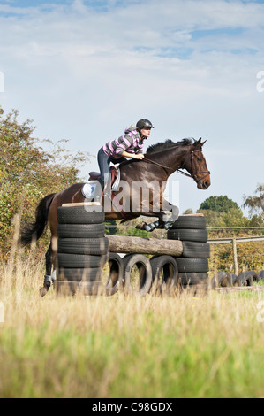 Cheval femelle cavalier au Cheval sautant sur l'obstacle de cross-country course.format vertical.copier l'espace. Banque D'Images