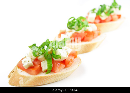 Les bruschetta avec de dés de tomates, mozzarella et basilic frais isolé sur blanc - Shallow DOF Banque D'Images