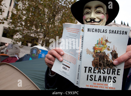 Militante de livre sur les paradis fiscaux d'Occupy London camp, la Cathédrale St Paul, à Londres Banque D'Images