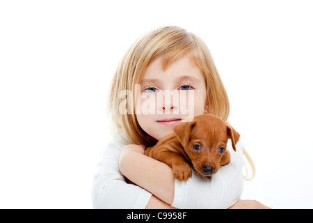 Enfants blonde girl with dog puppy mascot mini pinscher sur fond blanc Banque D'Images