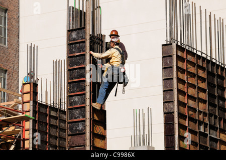 Les travailleurs de la construction le port du harnais de sécurité sur un chantier de construction à New York Banque D'Images