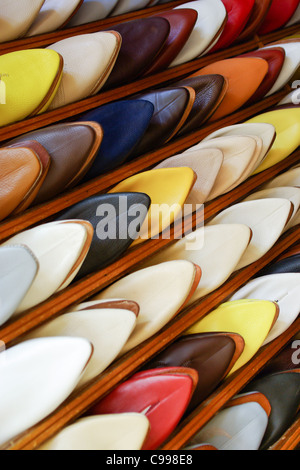 Les hommes marocains colorés silppers alignés sur une étagère à chaussures dans un magasin Banque D'Images