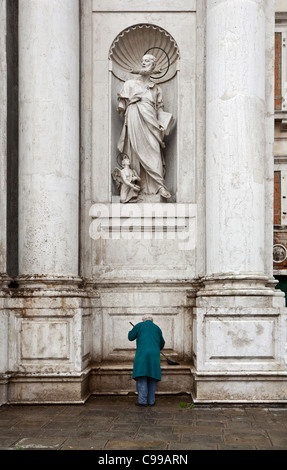 Façade de la Gesuiti (Santa Maria Assunta) à Venise montrant un apôtre dans une niche, avec un vieil homme les étapes de nettoyage Banque D'Images