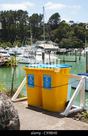 Déchets recyclage jaune wheelie bins. La marina à Tutukaka, Northland, Nouvelle-Zélande, île du Nord. Banque D'Images