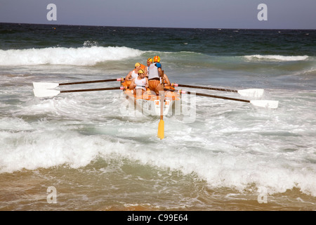 Équipage d'un bateau de sauvetage traditionnel australien surf bateau de sauvetage aviron dans une course au large de Newport Beach, Sydney, Australie Banque D'Images