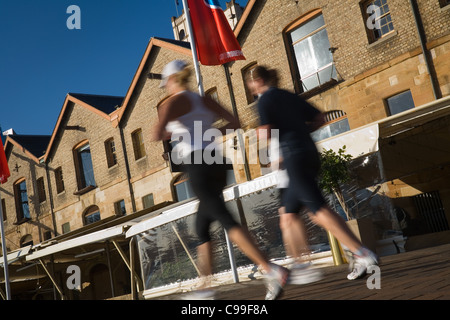 Les joggeurs du matin passer l'architecture historique de Campbell's Cove. The Rocks, Sydney, New South Wales, Australie Banque D'Images