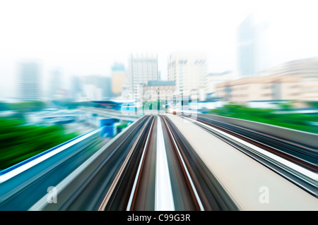 Sky train se déplaçant rapidement dans une ville brumeuse. Banque D'Images