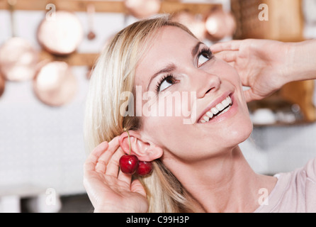 Italie, Toscane, Magliano, Close up of young woman holding cerises, smiling Banque D'Images