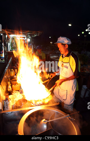 Thai man la cuisson au wok à feu la rivière Krabi marché nocturne. Banque D'Images