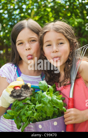 Germany, Bavaria, Sœurs faisant jardinage au jardin, smiling, portrait Banque D'Images