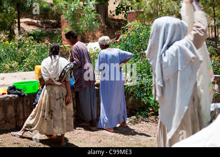 Des religieuses locales lavez les vêtements à la main près de la reine de Sheba's baignoire à Axoum, Nord de l'Ethiopie, l'Afrique. Banque D'Images
