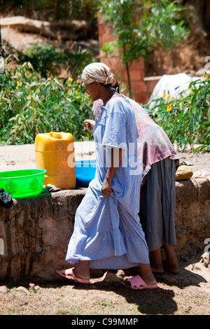 Des religieuses locales lavez les vêtements à la main près de la reine de Sheba's baignoire à Axoum, Nord de l'Ethiopie, l'Afrique. Banque D'Images