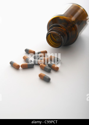 Pills spilling out of bottle on white background, close-up Banque D'Images