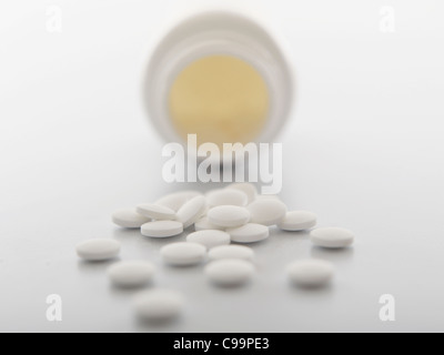 White pills spilling out of bottle, close-up Banque D'Images