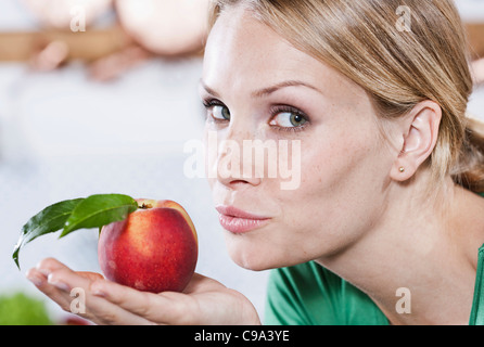 Italie, Toscane, Magliano, Close up of young woman holding apple, portrait Banque D'Images