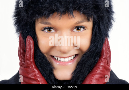En hiver : portrait of smiling friendly natural woman black hat en fausse fourrure rouge avec des gants de cuir. Banque D'Images