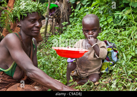 La mère et l'enfant de Mukuno, village batwa traditionnel de la tribu autochtone de la Forêt impénétrable de Bwindi en Ouganda. Banque D'Images