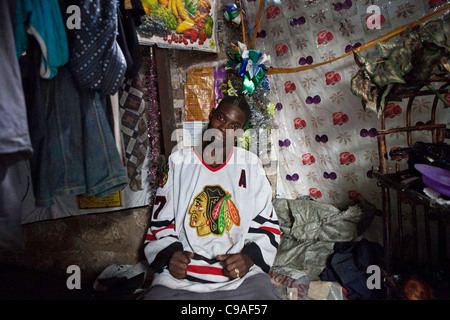 Boki, l'un des chefs de bande de base Mbaraki, dans le centre de Mombasa est assis dans son refuge. Au Kenya. Banque D'Images