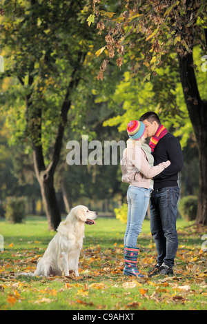 Petit ami et petite amie de s'embrasser dans le parc et un labrador retreiver dog Banque D'Images