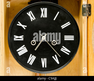 Ancienne horloge noir avec chiffres romains et des flèches. Horloge ancienne en boîte en bois. Banque D'Images