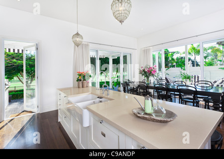 Cuisine ouverte élégante avec grande table à manger donnant sur une piscine et golf Banque D'Images