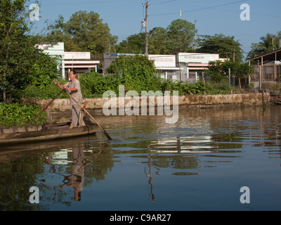 Woman rowing le bateau le long du fleuve dans le Delta du Mekong, Vietnam Banque D'Images