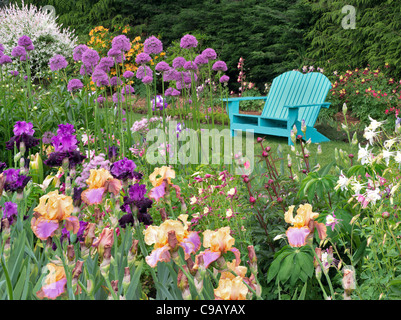 Iris et autres plantes à fleurs avec chaise à Schriners Jardin d'Iris. Oregon Banque D'Images