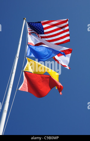 Drapeaux américains à partir d'un mât contre un ciel bleu Banque D'Images