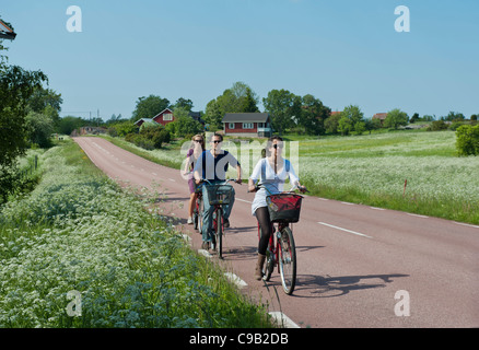 Trois jeunes adultes à vélo sur une route de campagne, Mariehamn Finlande Åland Banque D'Images